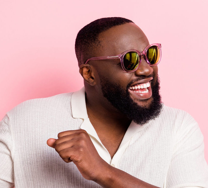 Man wearing sunglasses on a pink background dancing because he is excited about time in range!