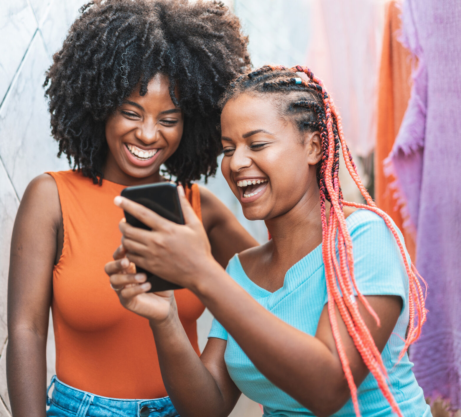 Two young women looking at their time in range on their phone and smiling happily!