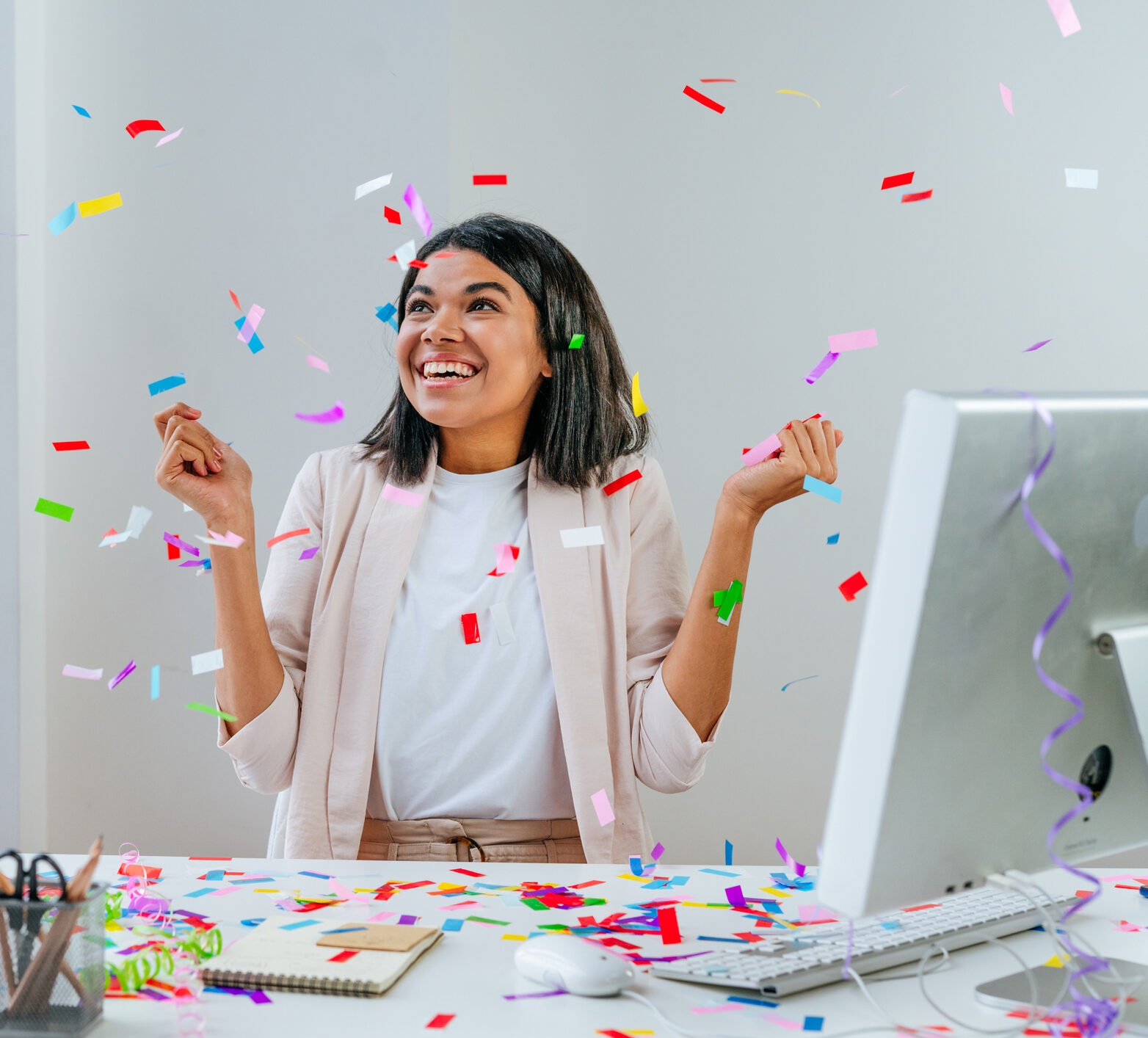 Young business woman having fun time catching confetti