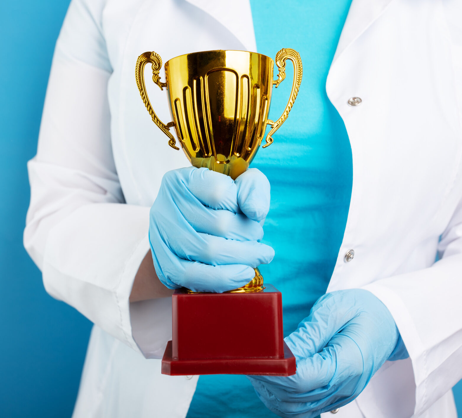 award cup in doctor's hands on blue background