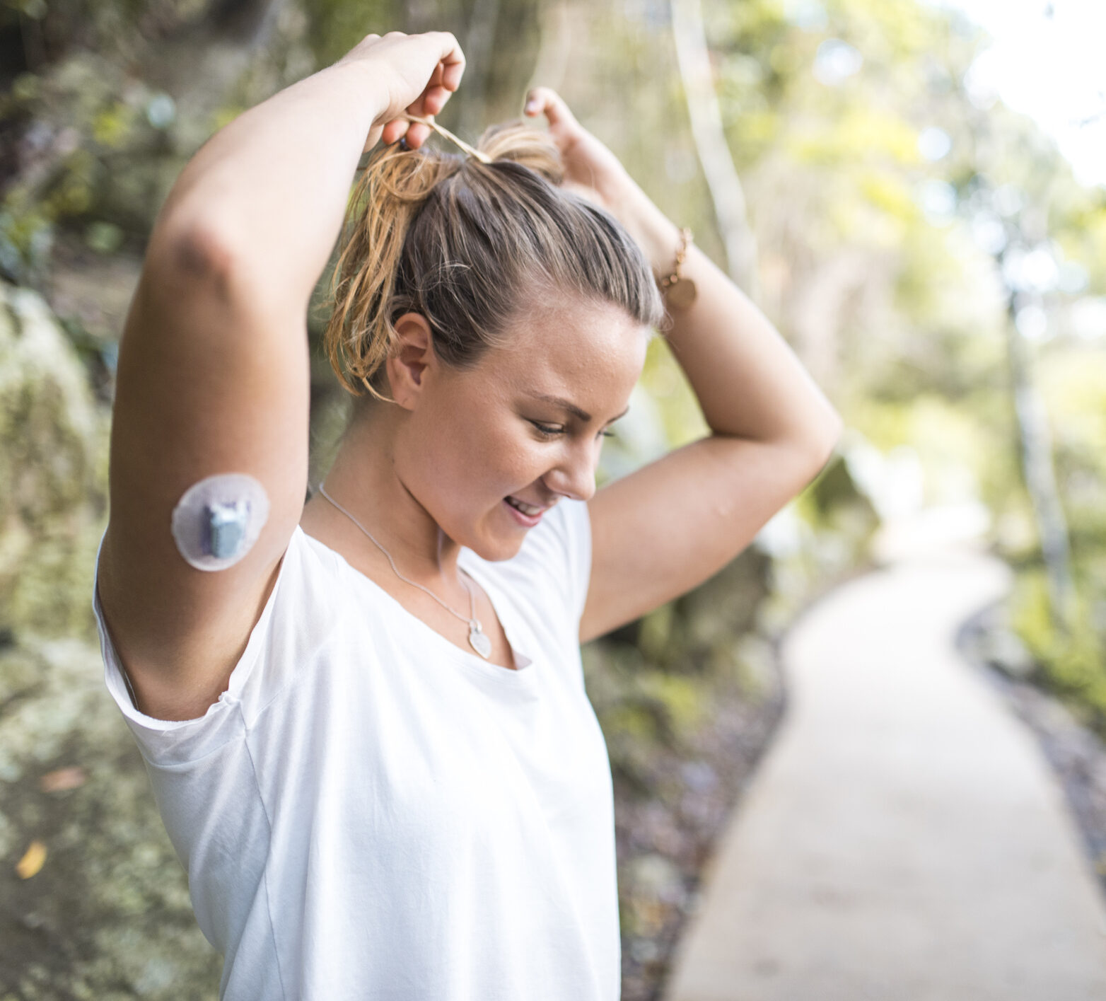 Blonde woman with CGM on her arm getting ready for a run