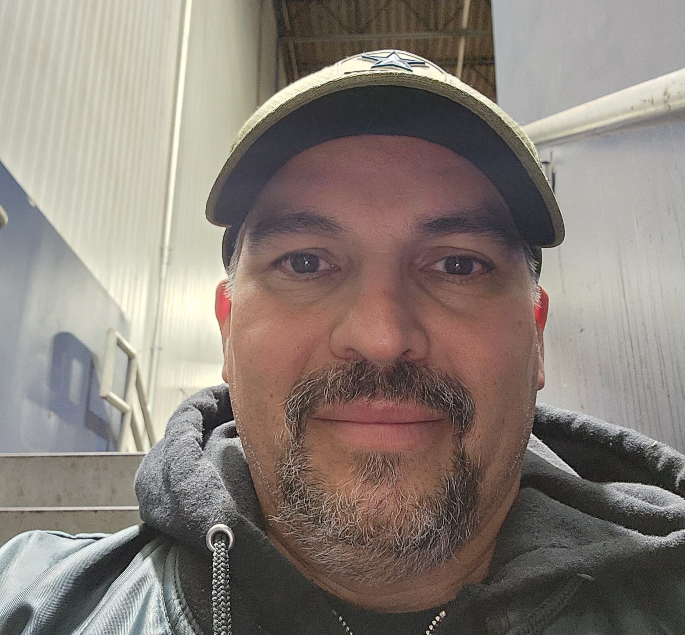 Photo of man, David Garza, smiling at the camera with baseball cap on. He has shared his story living with type 2 diabetes and using time in range.