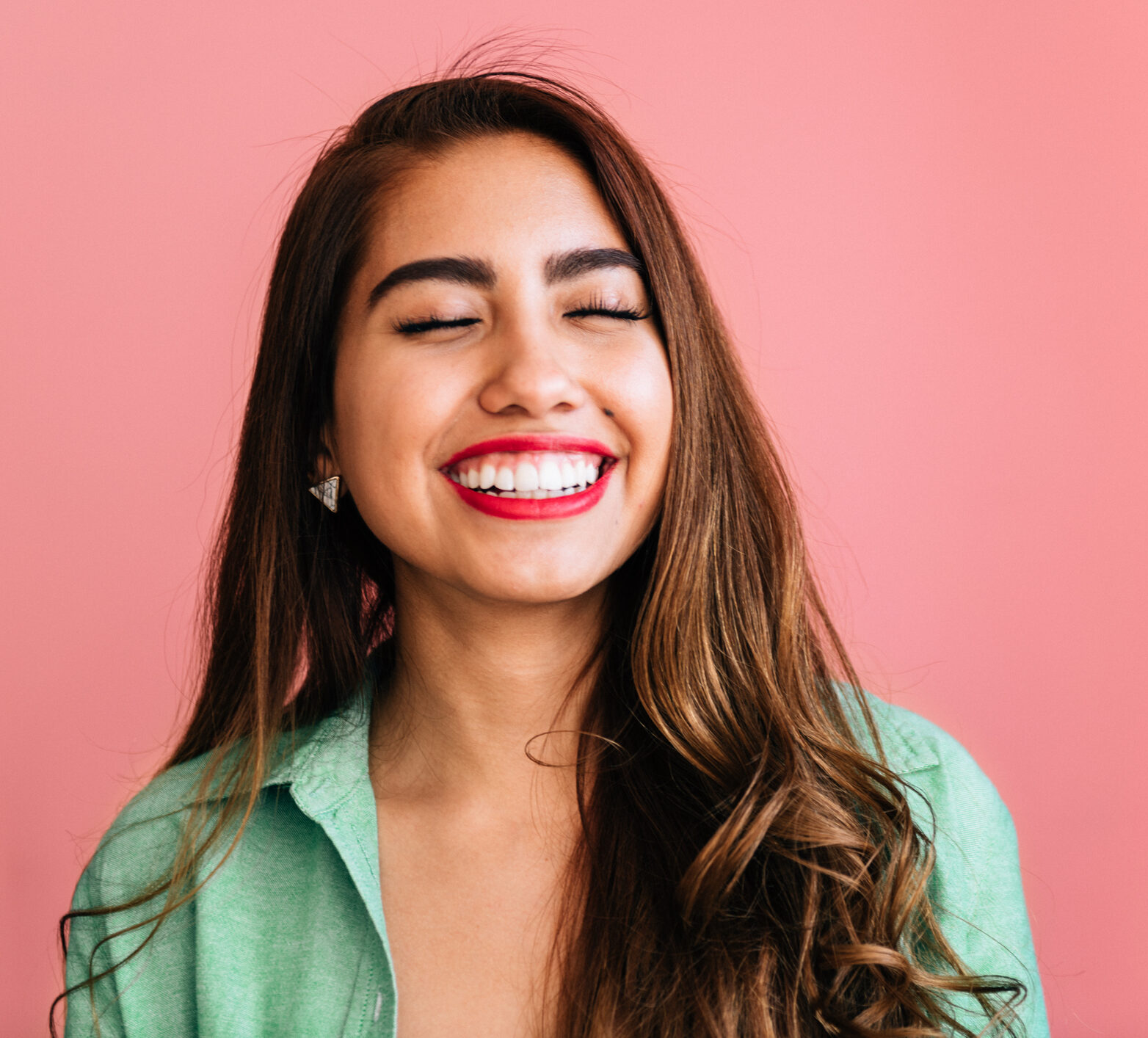 Woman smiling with pink background behind her