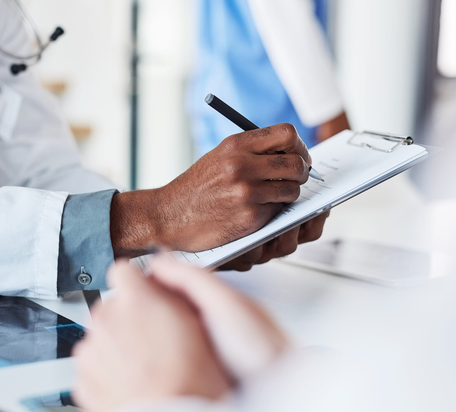 Closeup shot of an unrecognisable doctor writing on a clipboard in an hospital