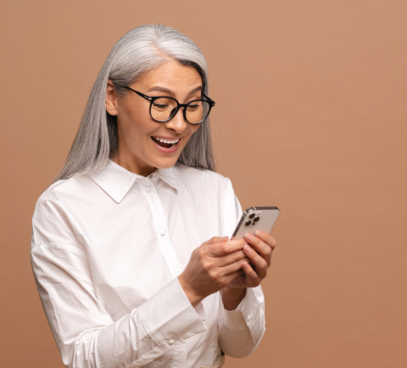 Woman with white hair looking at a phone app that helps read her patient's time in range - she is elated!