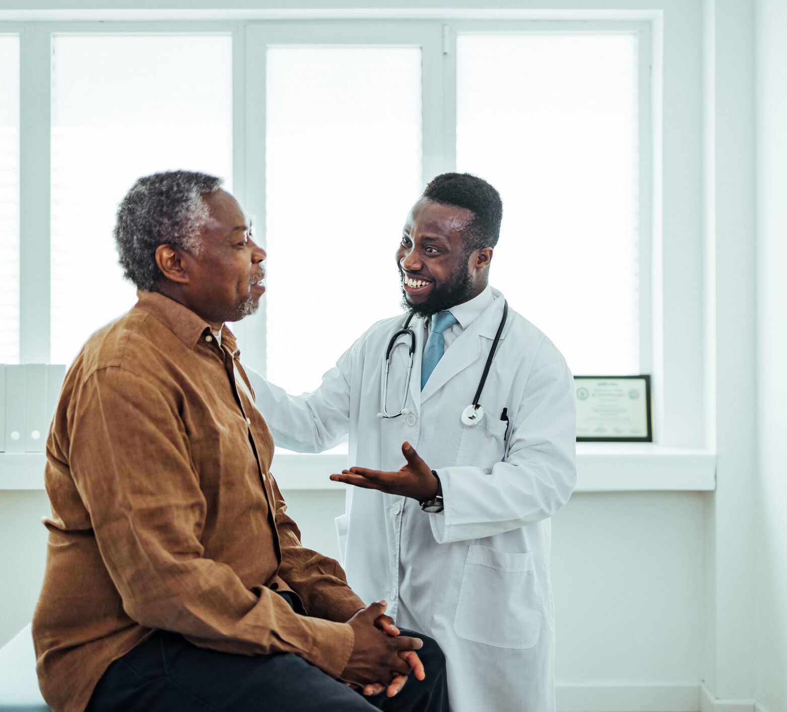 A male doctor chats to a male patient about time in range at a rural practice