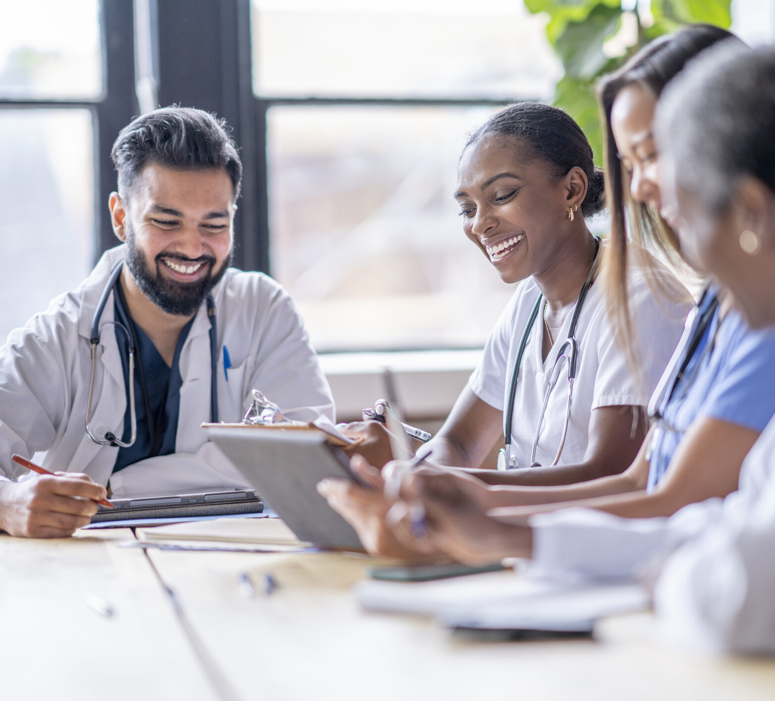 A small group of healthcare professionals seated around a table taking CGM trainings