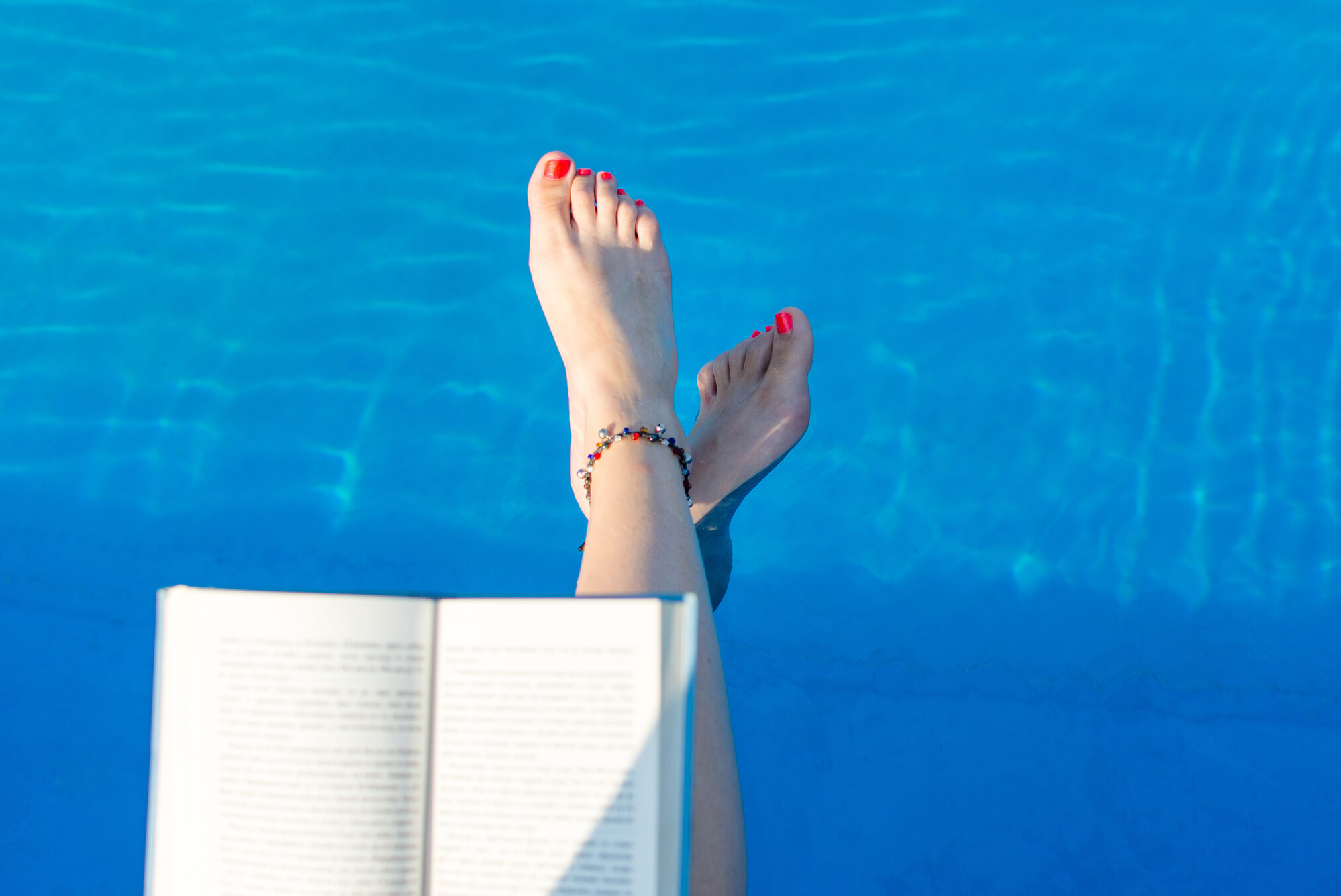 Girl reading by the swimming pool continuing her time in range education