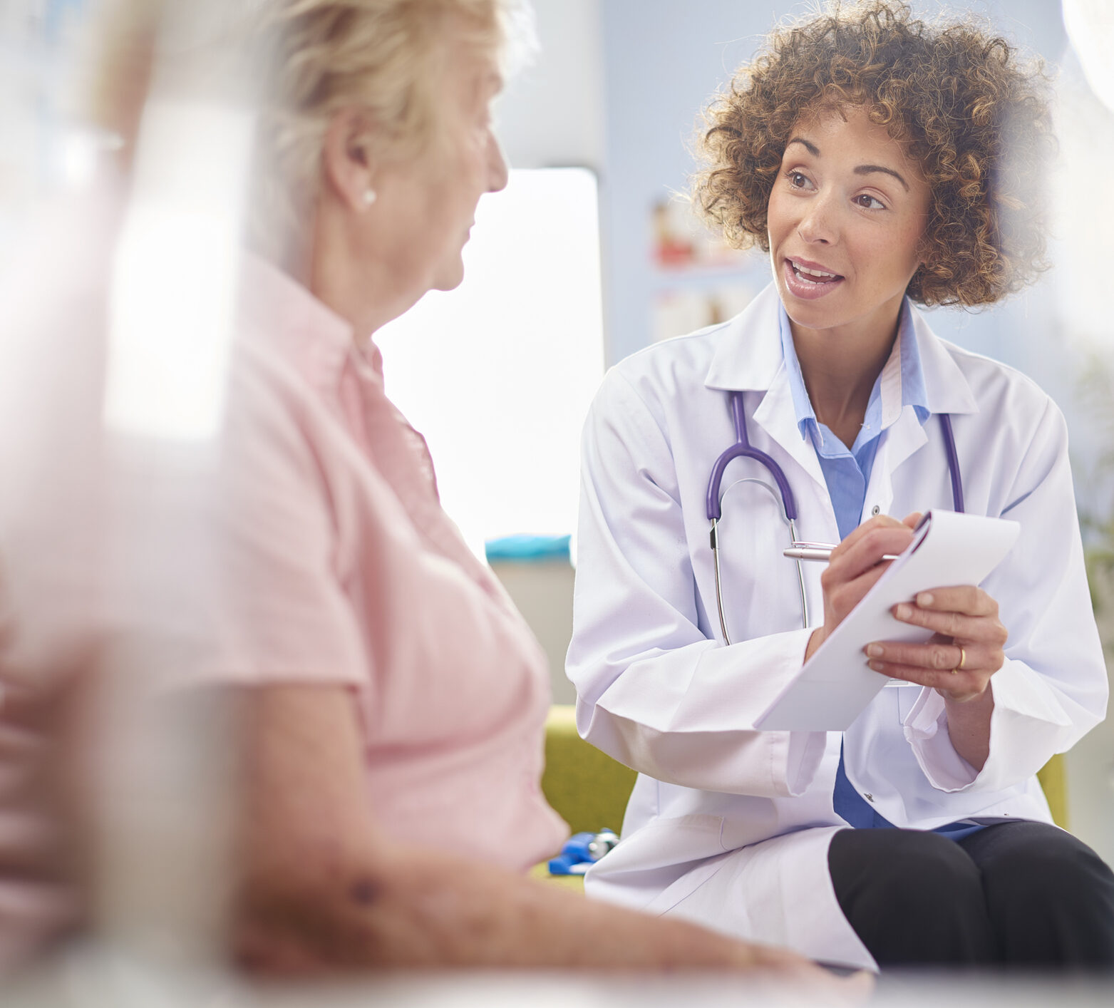 a female doctor sits and listens to a woman with diabetes talk about her fluctuations in her glucose levels