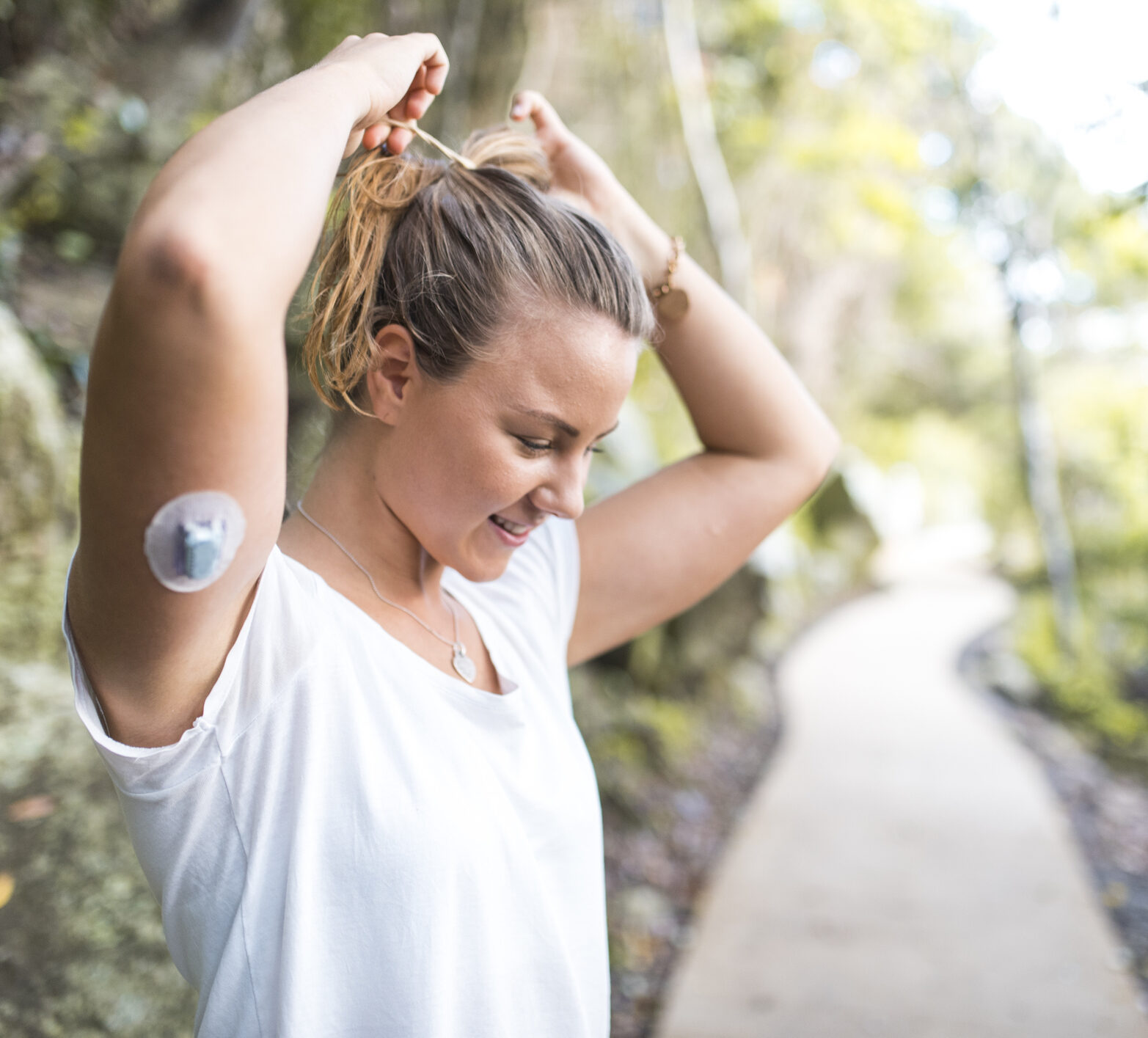 Woman with diabetes and a CGM on her arm preparing for a run